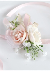 Dettaglio del corsage da polso con rose rosa e bianche e nastri di raso per matrimoni