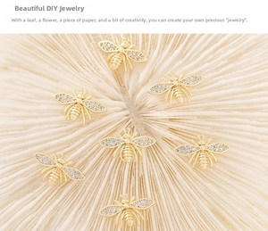 Macro shot of seven gold bee pendants with sparkling zircon wings for DIY jewelry