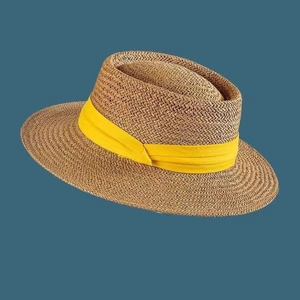 Detailed texture of hand-woven straw sun hat featuring a vibrant yellow decorative ribbon band