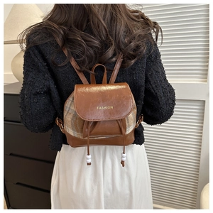 Details eines braunen Vintage Mini Rucksacks mit Karomuster und Goldaufdruck