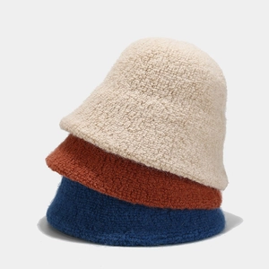 Solid color wool blend bucket hats in cream, caramel, and navy blue with fuzzy texture