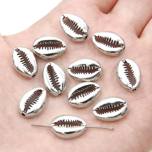 Close-up of silver vintage shell pendants being held in hand for DIY jewelry making