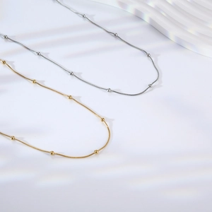 Minimalist 18K gold plated snake bone chain necklaces with beads on white background