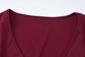 Vue détaillée macro des coutures du décolleté en V sur le haut bordeaux en tulle