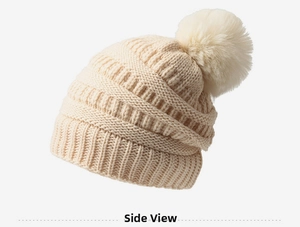 Vue latérale du bonnet en maille torsadée blanc cassé avec grand pompon en fourrure
