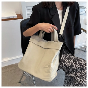 Close-up of lightweight off-white nylon tote bag with pleated texture and wide straps