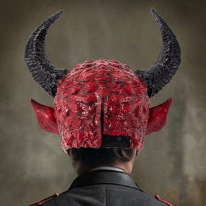 Rear view of a red devil Halloween mask with black horns and realistic latex texture