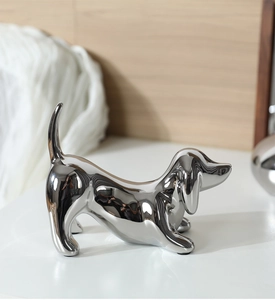 Macro detail of silver mirrored dachshund sculpture showing polished ceramic finish