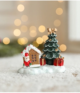 Scène de Noël miniature en résine avec Père Noël et maison sous des lumières bokeh
