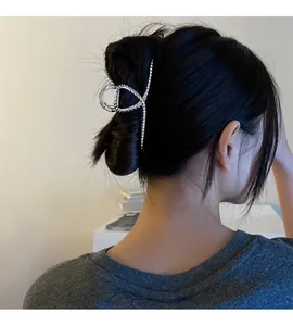 Detail of silver twisted metal hair claw clip worn on hair for a sleek updo style