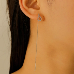 Close-up of elegant long tassel earrings with water drop pendants and sparkling crystals