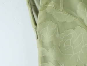 Detailansicht der hellgrünen Blumen-Jacquard-Stoffstruktur mit nahtlosem Reißverschluss