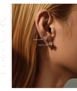 Detail showing 7mm and 8mm round-cut zirconia stud earrings on a model ear