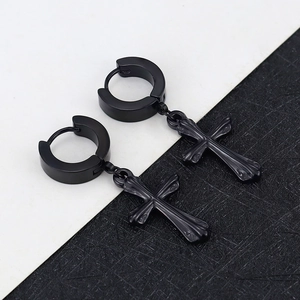 Detail shot of matte black stainless steel huggie hoop earrings with cross pendants