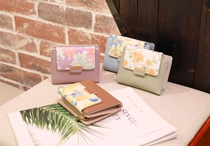 Détail de portefeuilles pour femmes en couleurs pastel avec rabats à motifs floraux