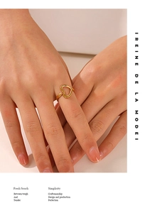 Close-up of golden heart-shaped open ring on finger showing adjustable fit and polished finish