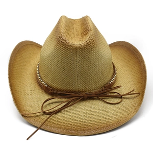 Détails d'un chapeau de cowboy en paille tressée avec bande en cuir brun et billes dorées