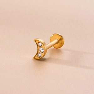 Macro shot of gold crescent moon lip stud with three sparkling cubic zirconia stones
