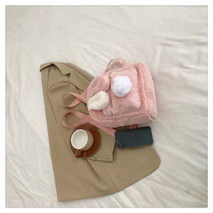 Detailed close-up of pink fluffy lamb wool backpack with cute long rabbit ears and soft textures
