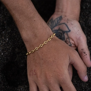 Minimalist geometric link bracelet in 18K gold plated stainless steel on a beach background