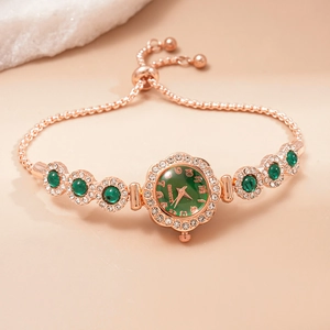 Detail view of rose gold bracelet watch with green dial and sparkling diamond accents