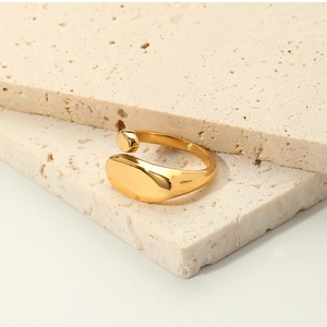 Macro shot of 18k gold plated stainless steel ring on beige stone background