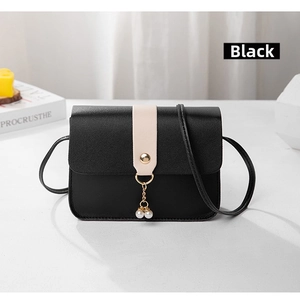 Close-up of black litchi pattern PU leather handbag with elegant double pearl pendant