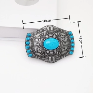 Macro view of vintage silver belt buckle with turquoise stones and ethnic engravings