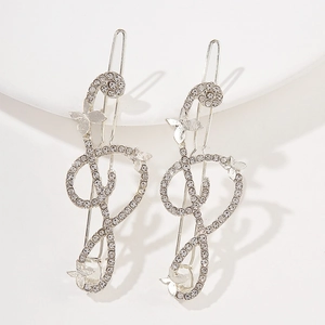 Silver musical note hair clips with rhinestones and butterfly accents on a white stand