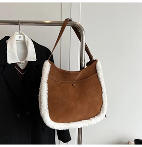 Detail view of caramel brown suede bucket bag featuring white faux shearling trim accents