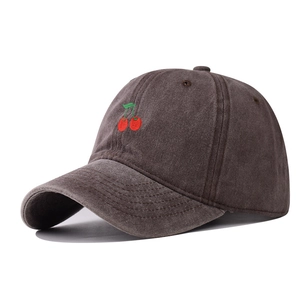 Detail of vintage washed cotton baseball cap with red cherry embroidery in dark brown