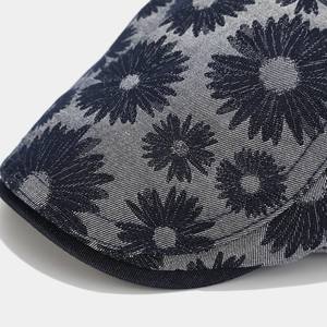 Detailed close-up of dark blue daisy print fabric and reinforced stitching on a visor hat