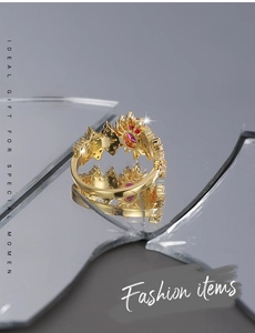 Close-up of golden sunflower ring with pink gemstone on reflective mirror surface