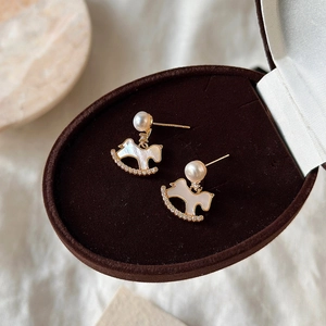 Gold-plated rocking horse pearl earrings with shell texture and diamond accents