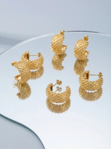 Detailed view of C-shaped crisscross grid pattern earrings with 18k gold plating finish