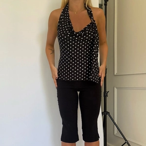 Haut à pois avec dos nu présenté sur un mannequin pour une tenue d'été tendance