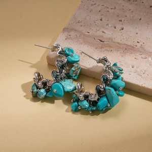 Detail of wave-shaped turquoise earrings with irregular stones on silver metal base