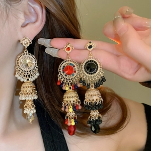 Detailed view of Bohemian dangle earrings with crystals and tassels worn on ear