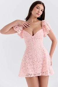 Detailed macro view of the light pink floral lace fabric and delicate butterfly sleeves