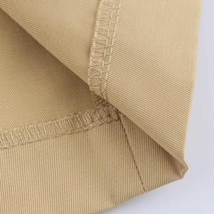 Detail shot of khaki twill fabric showing high-quality overlock stitching and hem finish