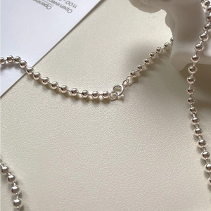 Detailed close-up of a 925 sterling silver ball chain necklace with a spring clasp closure