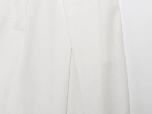 Close-up of premium white textile fabric texture showing intricate weave and soft pleats