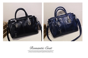 Detail view of oil wax leather Boston bags in black and navy blue with woven handles