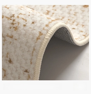 Macro detail of hand-overlocked edges on a cream cream-colored waterproof rug with abstract patterns
