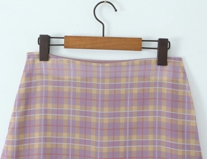 Detailed macro view of purple and yellow plaid fabric on a high-waisted ruffled skirt