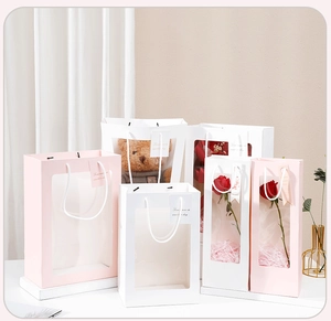 Detail view of pink and white gift bags with transparent windows for dolls and flowers