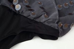 Detail of grey mesh fabric with sequin embroidery and black elastic knit lining
