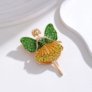 Detailed close-up of a golden fairy brooch featuring green and yellow crystal wings
