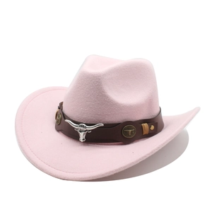Détail d'un chapeau de cowboy en laine rose avec bande en cuir et tête de taureau