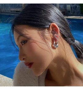 Gros plan de boucles d'oreilles créoles en argent poli portées par un mannequin